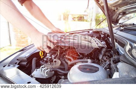 Mechanic Starts Repairing Modern Diesel Car Engine, Background. Sun