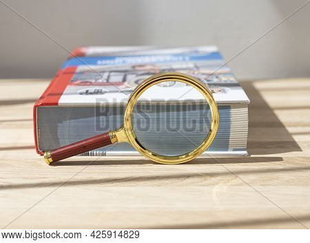 Magnifier Near Thick Technical Book For Education. Concept Of Scientific Knoledge And Study.