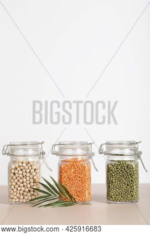 Vegan Protein Source. Chickpeas, Lentils, Mung In Glass Jars On White And Beige Background. Healthy 