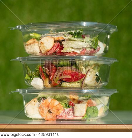 Ready-to-eat Food, Three Transparent Plastic Containers With Salads On Green Background. Tower From 