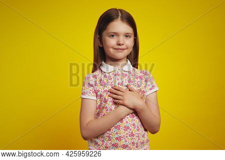 Beautiful Smiling Caucasian Girl Keeps Palms On Heart, Expresses Appreciation, Pleasure And Gratitud