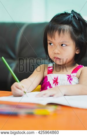 Vertical Images. Portrait Of Cute Asian Girl Showing Dissatisfaction While Doing Homework. Child Was