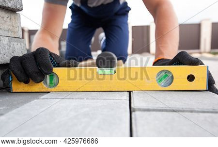 Worker lining paving slabs path