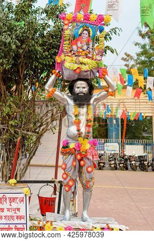 A Unidentified Man Painted His Body With Silver Colour And Holding A Picture Of Lord Krishna Posed A