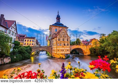 Bamberg, Germany. Town Hall Of Bamberg (altes Rathaus) With Two Bridges Over The Regnitz River. Uppe