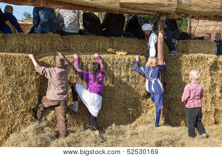 Children trying to climb a wall of hay bales during the Dutch agricultural festival Flaeijel