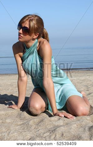 Woman In Dress And Sunglasses On The Beach