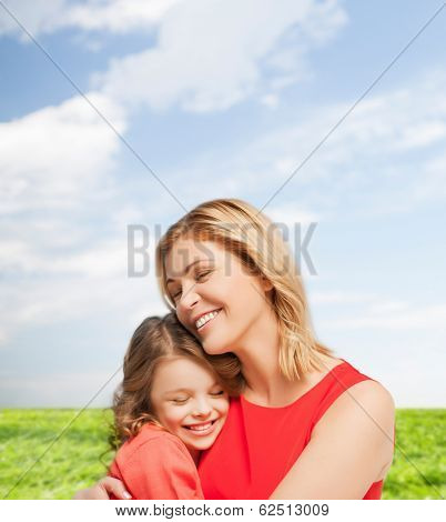 family, child and happiness concpt - hugging mother and daughter