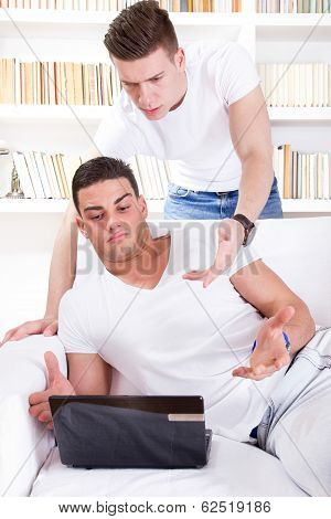 Two Surprised Young People Looking At Laptop