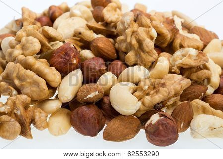 mixed nuts - hazelnuts walnuts cashews pine nuts isolated on white background