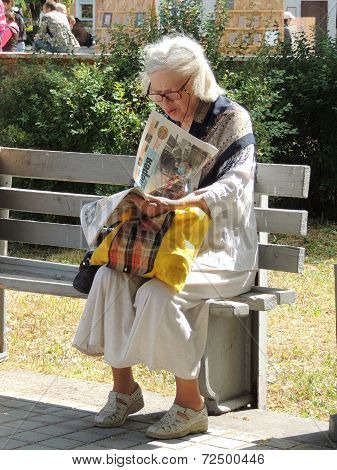 Woman Reading On A Bench