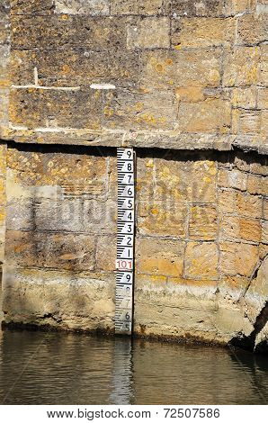 Depth marker on stone bridge.