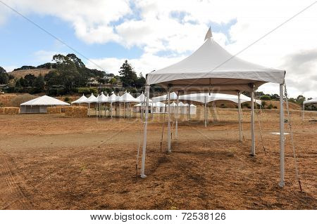 White Tents In A Dry Field Outdoors