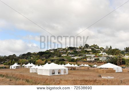 White Tents In A Dry Field Outdoors
