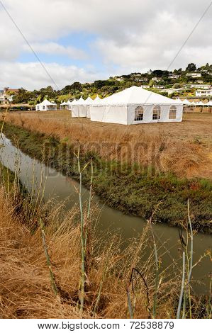 White Tents In A Dry Field Outdoors