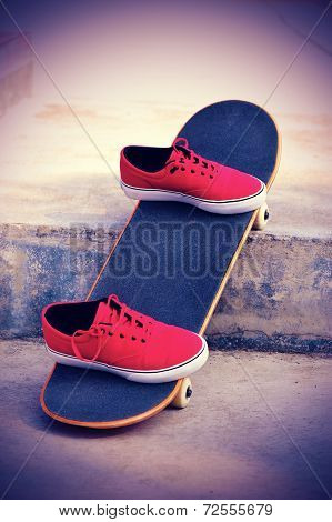 skateboard and red sneakers at outdoor skatepark