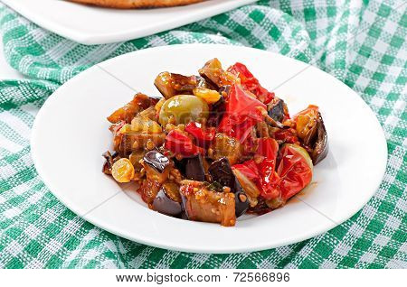 caponata with raisins and pine nuts decorated with a leaf of basil