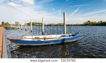 Moored Iron Rowing Boat In Rippling Water
