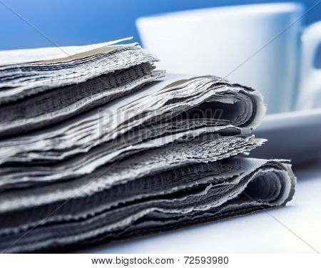 Newspaper and coffee cup.Blue background