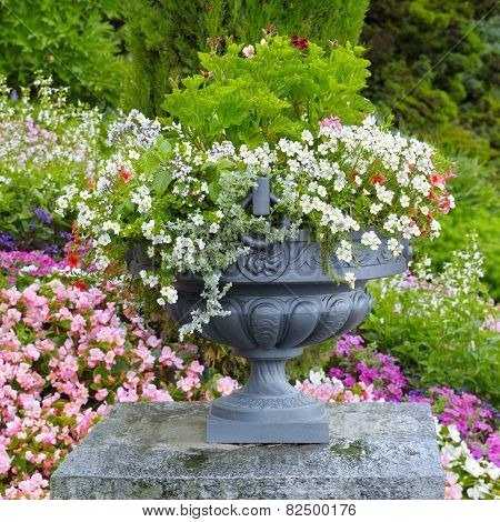 Flower Bed And Stone Vase With Flowers