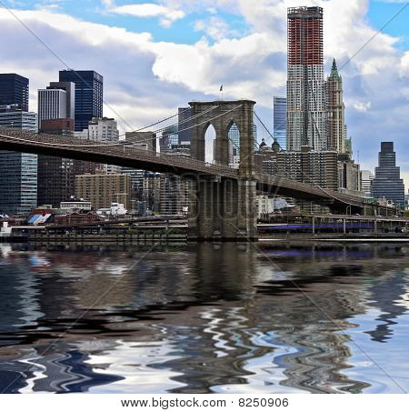 Historic Brooklyn Bridge and lower Manhattan reflected in East River