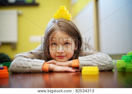 Happy beautiful girl plays with blocks