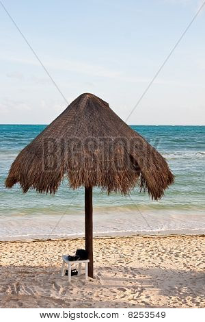 Sandali spiaggia sotto l'ombrellone in paglia