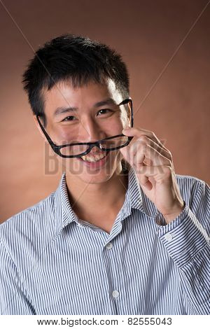 Young Chinese frank businessman, closeup portrait in studio.