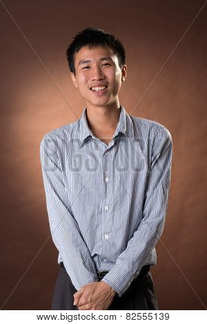 Young Chinese frank businessman, closeup portrait in studio.