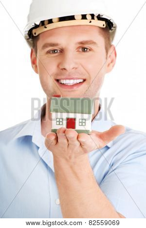 A forewoman holding a model house in hand