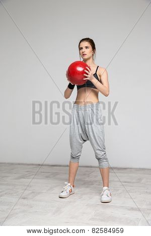 Beautiful sports woman working out with a medicine ball