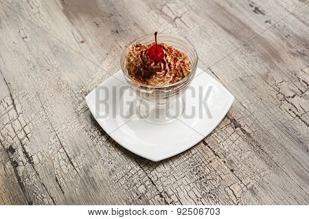 Ice Cream With Chocolate Crumb And Cherry On White Plate