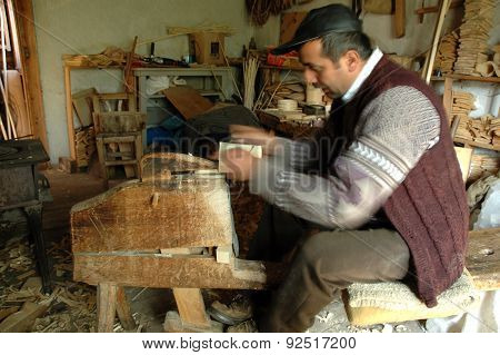 Carpenter Handcrafting A Wooden Alpenhorn