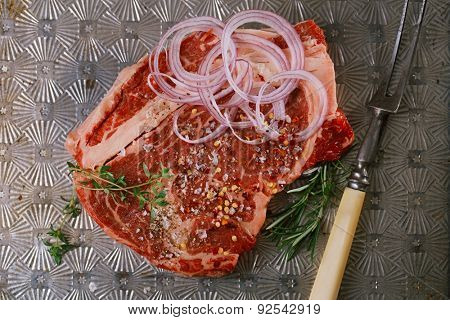 beef steak t-bone with vintage meat fork on metal backdrop