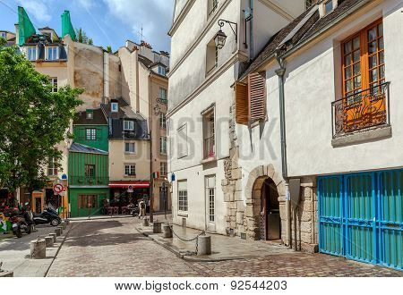 Narrow street among typical parisian buildings in Paris, France.