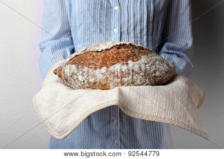 Woman holding tasty fresh bread, close up