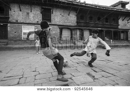 KATHMANDU, NEPAL - CIRCA DEC, 2013: Unknown children play football after lesson at Jagadguru School. School established in 2013, to let new generation learn Sanskrit and preserve Hindu culture.