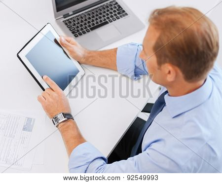 business, office, school and education concept - businessman with tablet pc and papers in office