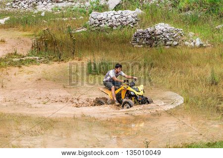 Off Road On Quad Bike Rally Over Mud Puddle