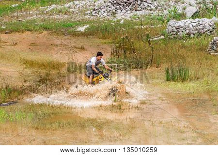 Off Road On 4X4 Quad Bike Through Mud Puddle