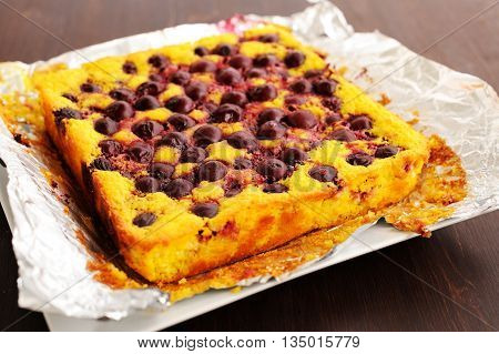 Homemade yummy quark pie with cherries baked in foil closeup