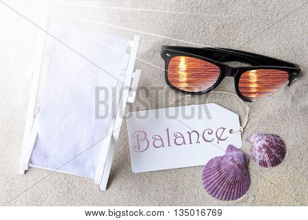 Sunny Summer Label With English Text Balance. Flat Lay View. Summer Decoration With Deck Chair, Seashells And Sunglasses. Greeting Crad With Sand Background