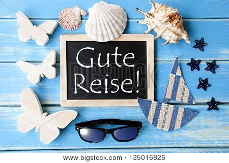 Flat Lay Of Chalkboard On Blue Wooden Background. Nautical Summer Decoration As Holiday Greeting Card. German Text Gute Reise Means Good Trip
