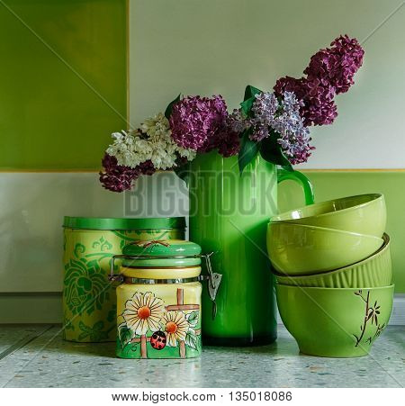 Ceramic Plates and Jars.Tableware,Bouquet of Lilac in the Green Pitcher.