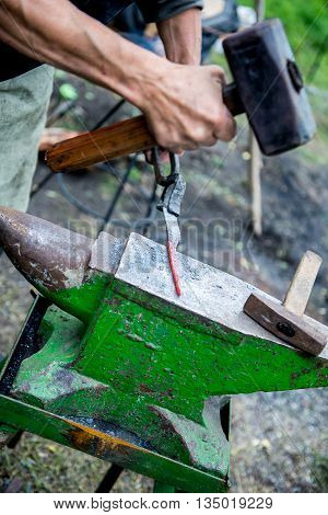 blacksmith forges detail. Blacksmith working outdoors. Master works on the anvil.