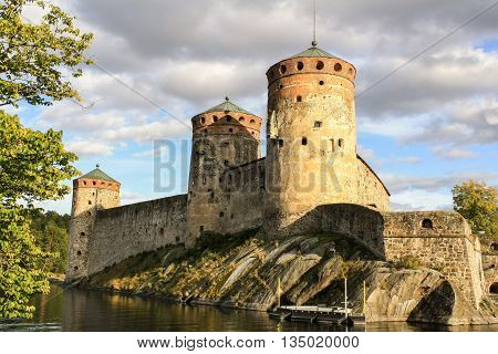 Ancient fortress Olavinlinna in Savonlinna in Finland among the trees a summer day.