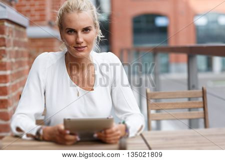 Portrait of a beautiful girl at the table with tablet. tilt-shift effect
