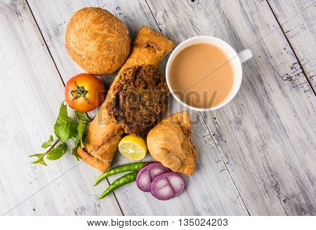 coriander vada or kothimbir vada, samosa, kachori, daal vada on brown wooden planks. indian assorted snacks. Indian snacks combination. Indian snacks group, indian favourite snacks, asian spicy snacks