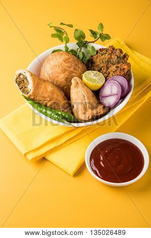 coriander vada or kothimbir vada, samosa, kachori, daal vada on brown wooden planks. indian assorted snacks. Indian snacks combination. Indian snacks group, indian favourite snacks, asian spicy snacks
