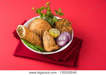 coriander vada or kothimbir vada, samosa, kachori, daal vada on brown wooden planks. indian assorted snacks. Indian snacks combination. Indian snacks group, indian favourite snacks, asian spicy snacks